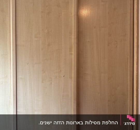 ארון הזזה מעץ בהיר עם דלתות במסילה עליונה